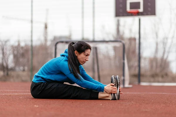 一位年轻妇女在操场上从事体育活动 俄罗斯早春 图库图片