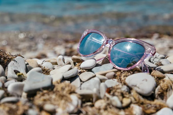 海滩上粉色眼镜上的倒影娱乐和旅行的概念 Gelendzhik Russia 图库照片