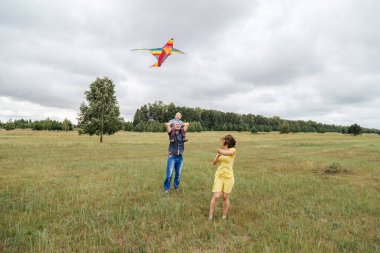 Bir aile sahada uçurtma uçuruyor. Kırsal alan, Rusya.