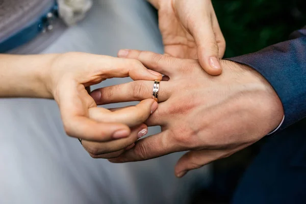 Noiva usa o anel no dedo do noivo — Fotografia de Stock