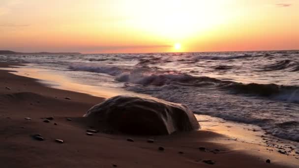 Una grande roccia sulla spiaggia al tramonto — Video Stock