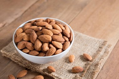 Badem ahşap masa üzerinde beyaz kase