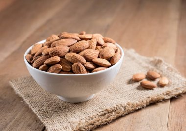 Badem ahşap masa üzerinde beyaz kase