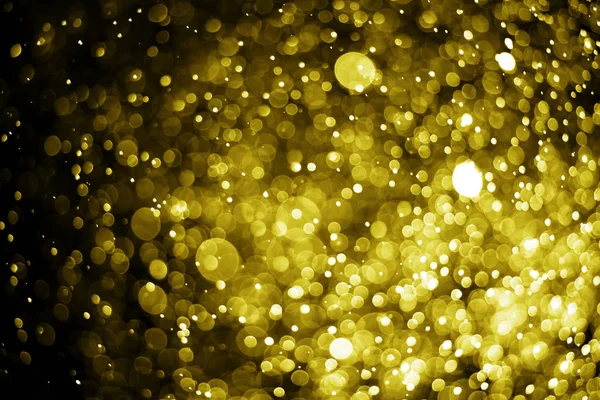 Bokeh luz de ouro no fundo preto — Fotografia de Stock