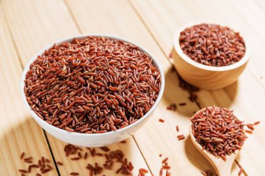 Pirinç berry ahşap arka plan üzerinde beyaz kase