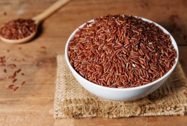 Pirinç berry ahşap arka plan üzerinde beyaz kase