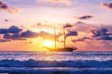 Sahil kumu ve alacakaranlık deniz günbatımı ve güneş ışını ile tekne