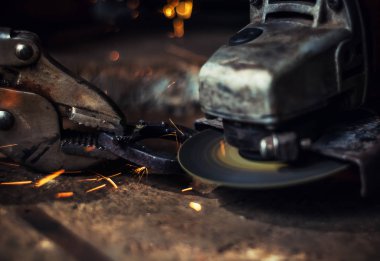 Çelik kesici aracıyla siyah arka plan üzerine bulanık adamın elini