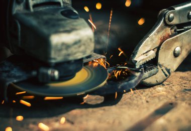 Çelik kesici aracıyla siyah arka plan üzerine bulanık adamın elini