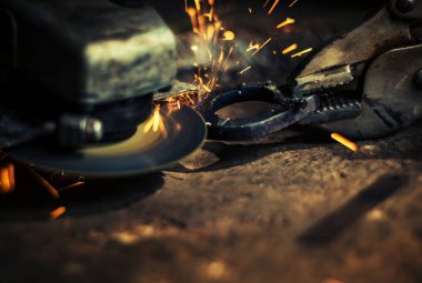 Çelik kesici aracıyla siyah arka plan üzerine bulanık adamın elini