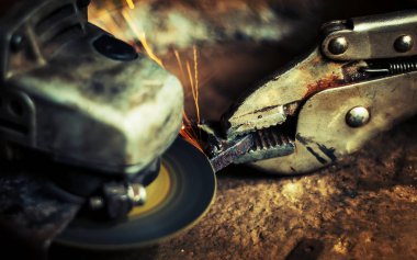 Çelik kesici aracıyla siyah arka plan üzerine bulanık adamın elini