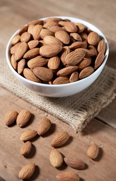 Almond snack fruit in white bowl on wooden