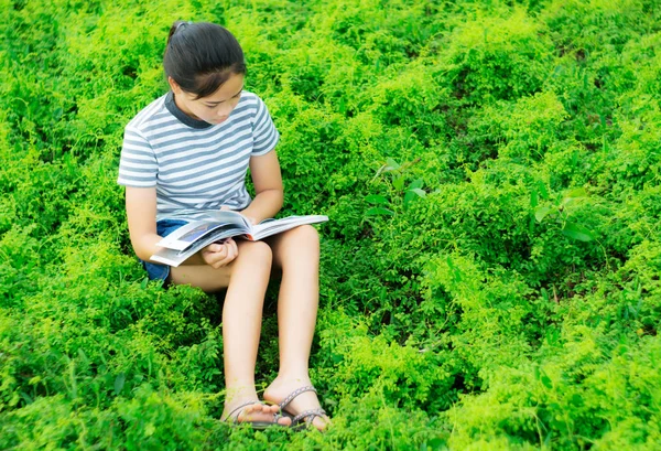 Młoda dziewczyna czytanie w natura zielony łąka contryside wieczorem — Zdjęcie stockowe