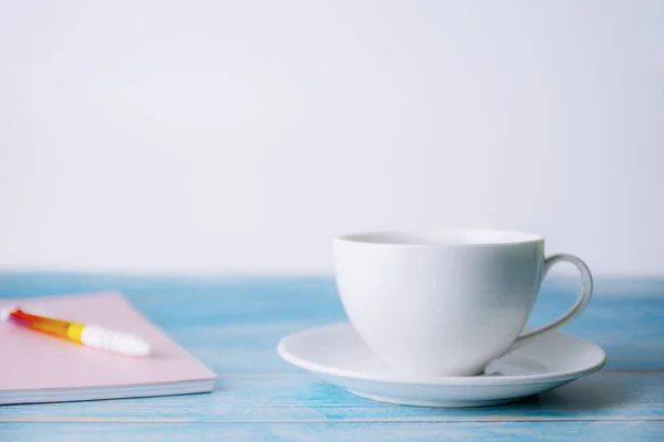 Una taza de café con cuaderno de madera —  Fotos de Stock