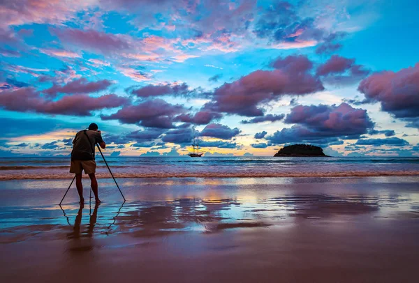 Sahilde güneşin rengiyle çekim yapan fotoğrafçı.