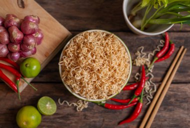 Limonlu, biberli, soğanlı, ahşap masada sebzeli erişte. Arka plan bulanık.