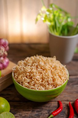 Limonlu, biberli, soğanlı ve ahşap masa üzerindeki sebzeli erişte.