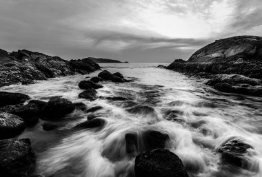 Gün batımı ya da gün doğumu gökyüzü ve bulutlarla dolu alacakaranlıkta güneş ışığı, siyah ve beyaz ve tek renkli