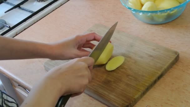 Las manos femeninas cortan patatas crudas en tiras. Cocina casera . — Vídeos de Stock