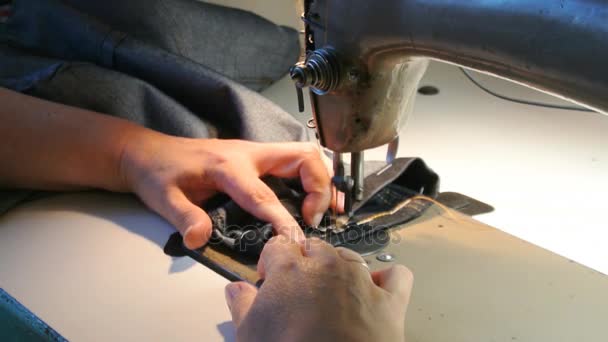 Huis naaister naait. Vrouwelijke handen naai jeans. Een naaimachine werkt. — Stockvideo