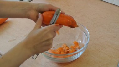 Kadın soyma çiğ havuç eller. Ev mutfak.