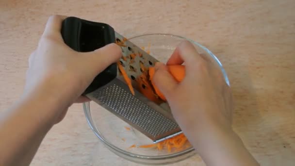 Női kezét Faaprító nyers sárgarépa, amelynek simítóval. Otthoni konyha. — Stock videók