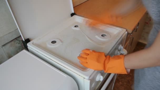 Mujer joven limpia la estufa — Vídeos de Stock