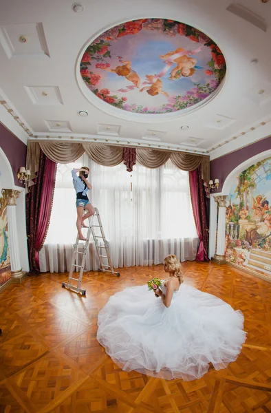 Молодой сексуальный фотограф фотографирует невесту — стоковое фото