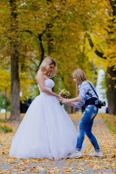Wedding photographer shows to bride how to hold bridal bouquet