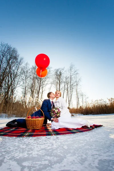 Braut und Bräutigam sitzen mit Luftballons auf dem Karo — Stockfoto