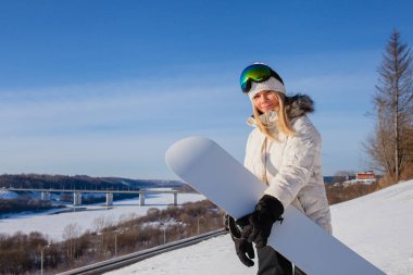 Genç kadın ve onun beyaz snowboard kar kaplı dağın üzerinde