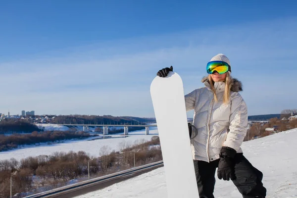 Junge Frau und ihr weißes Snowboard am schneebedeckten Berghang — Stockfoto