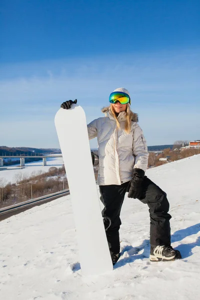 Junge Frau und ihr weißes Snowboard am schneebedeckten Berghang — Stockfoto