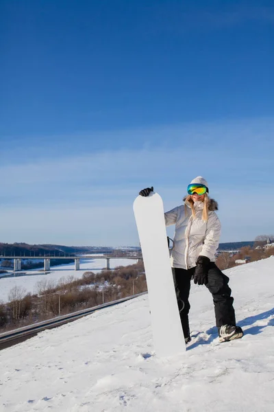 Giovane donna e il suo snowboard bianco sulla montagna innevata — Foto Stock