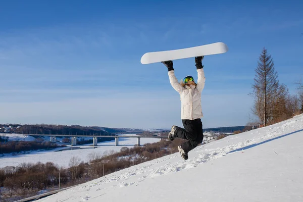 Ung kvinna hoppa med sin snowboard — Stockfoto