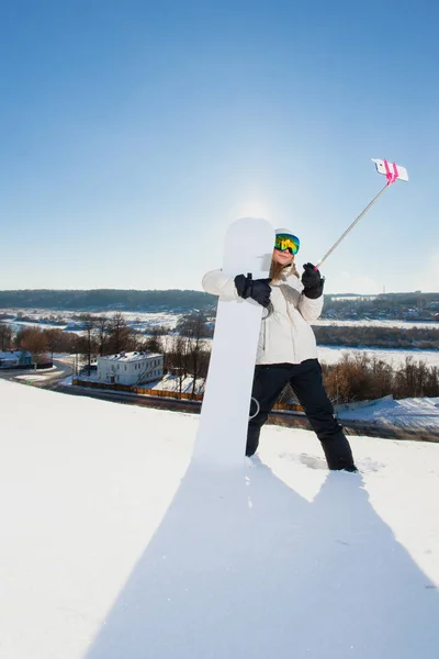 Giovane donna con lo snowboard scattare un selfie dal suo telefono cellulare — Foto Stock