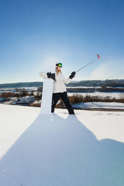Giovane donna con lo snowboard scattare un selfie dal suo telefono cellulare — Foto Stock