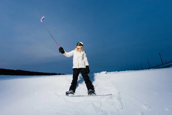 Νεαρή γυναίκα με το snowboard να τραβήξεις ένα selfie από κινητό τηλέφωνο — Φωτογραφία Αρχείου