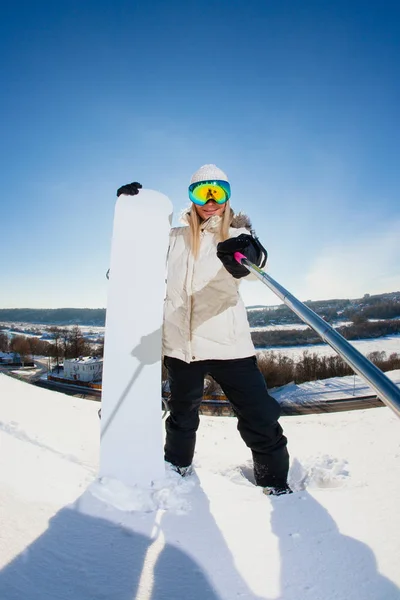 Junge Frau mit dem Snowboard schießt ein Selfie mit ihrer Action-Kamera — Stockfoto