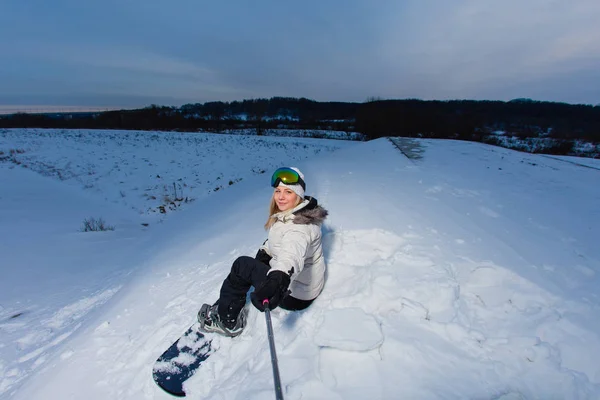 Молодая женщина с сноубордом снимает селфи на камеру — стоковое фото