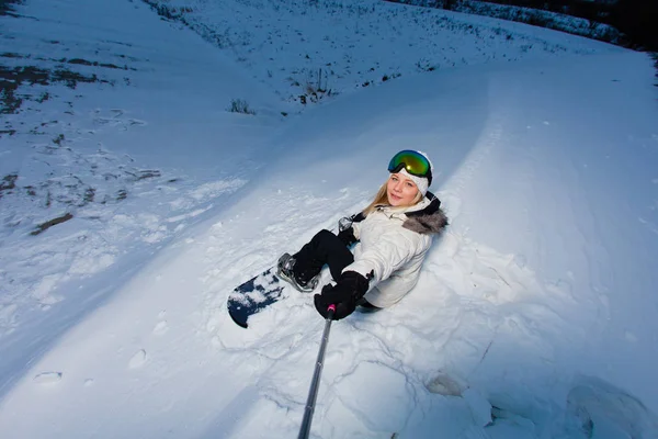 Νεαρή γυναίκα με το snowboard να τραβήξεις ένα selfie από της δράσης κάμερα — Φωτογραφία Αρχείου