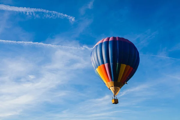 Barevný horkovzdušný balón na modré obloze — Stock fotografie
