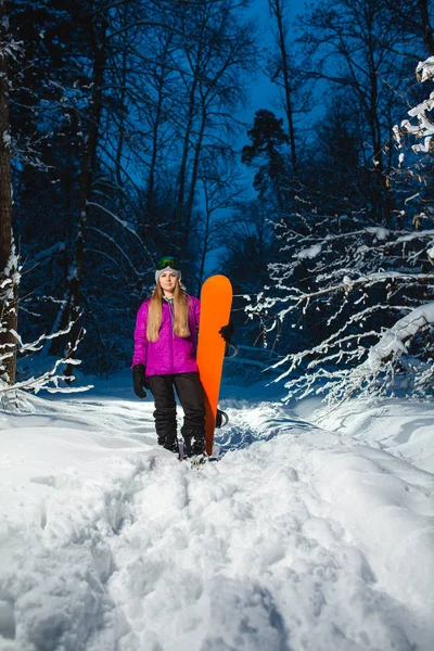 Junge sexy Frau mit ihrem Snowboard im dunklen Winterwald — Stockfoto