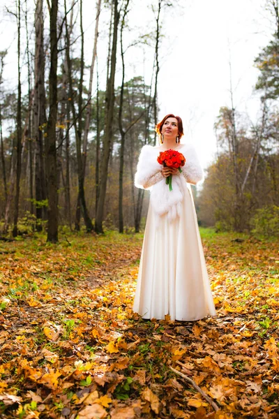 Brautporträt im herbstlichen Park und Brautstrauß — Stockfoto