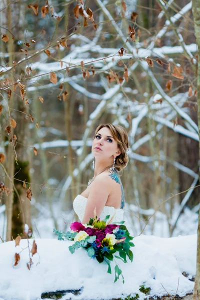 Retrato de la novia en el frío bosque de invierno con un hermoso ramo de novia — Foto de Stock