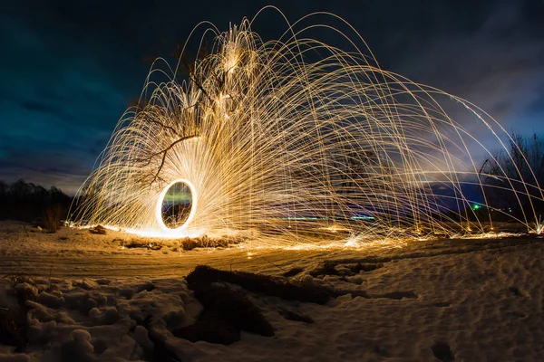 燃えている火花の軌道付近の春の夜の風景の背景の木 — ストック写真