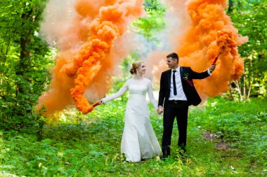 Gelin ve damat ile turuncu yaz orman arka plan duman renkli