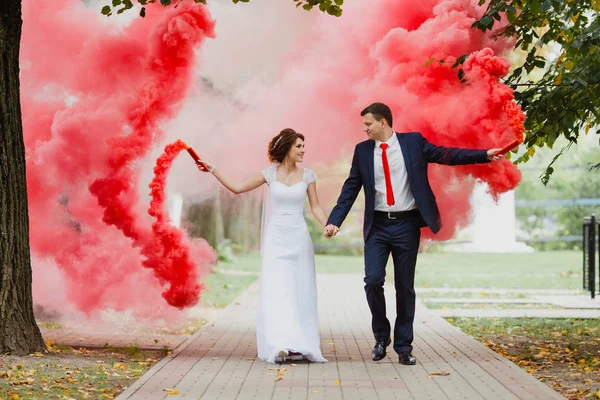Sposa e sposo con il fumo rosso — Foto Stock