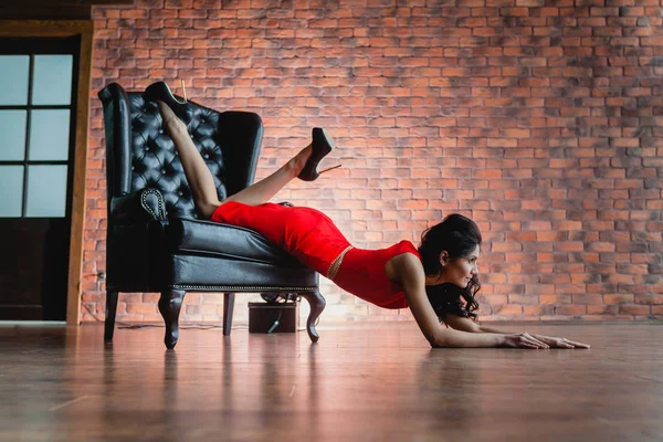 Slender brunette lying on a black armchair — Stock Image Slender brunette lying on a black armchair Royalty Free Stock Images