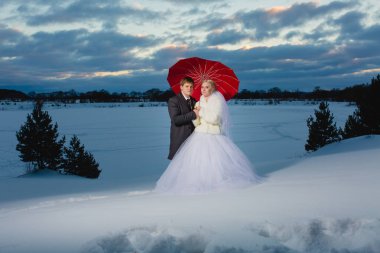 Gelin ve damat ile büyük kırmızı şemsiye